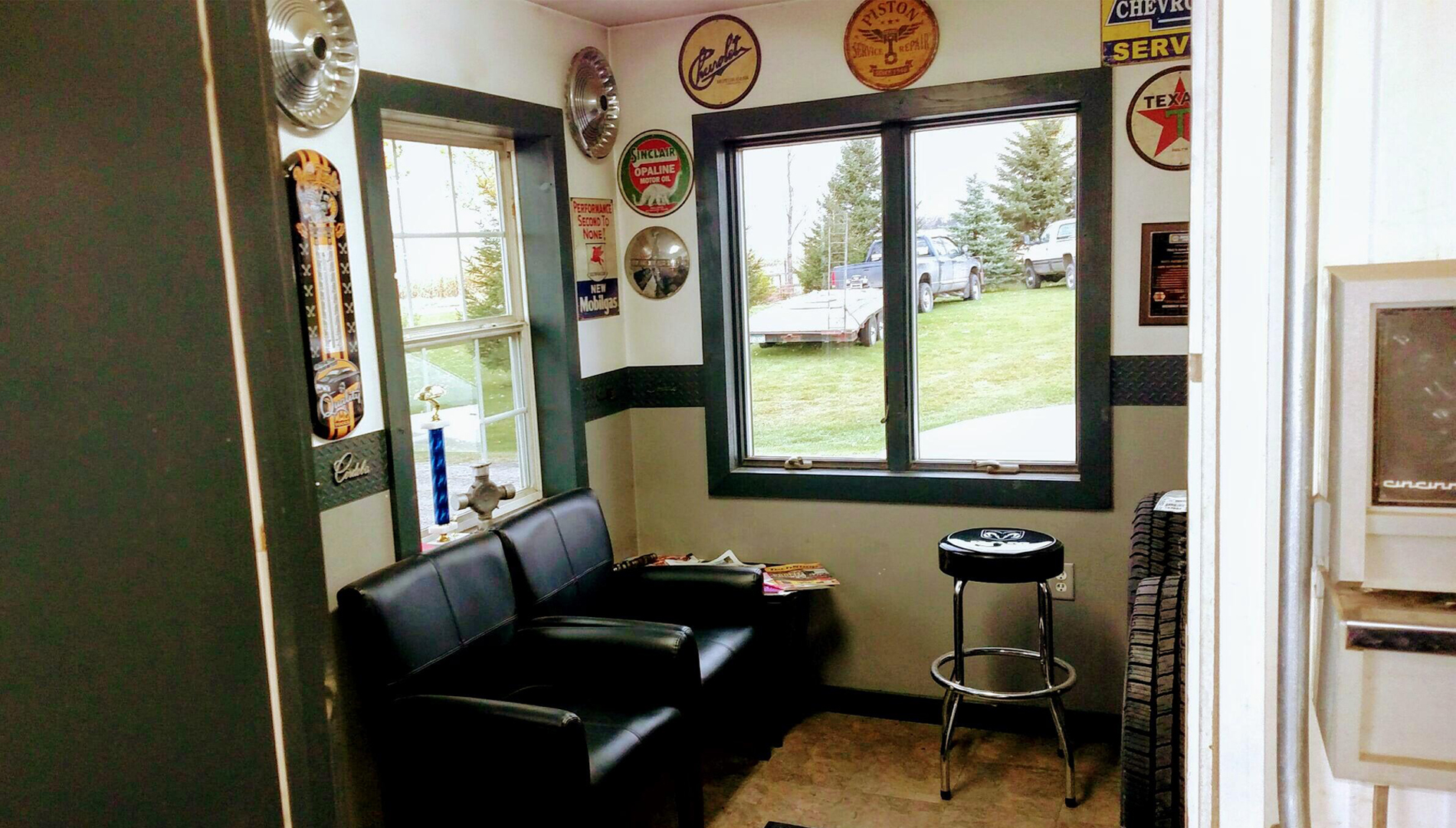 The shop’s waiting area with seating and vintage automotive signs
